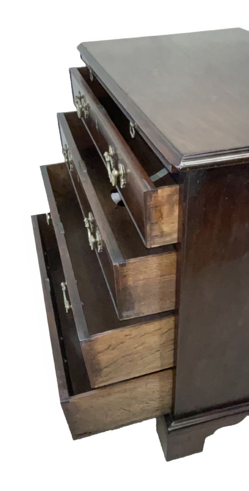 fig 1. An eighteenth-century Georgian mahogany chest of drawers featuring four graduated drawers, brass swan-neck handles, and bracket feet.