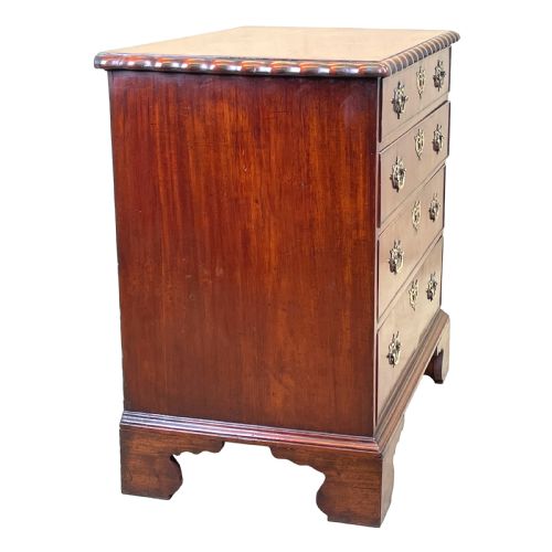fig 1. An 18th-century walnut chest of drawers featuring four graduated drawers with ornamental brass handles and escutcheons resting on shaped bracket feet.