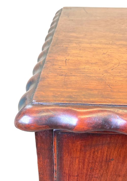 fig 2. An 18th-century walnut chest of drawers featuring four graduated drawers with ornamental brass handles and escutcheons resting on shaped bracket feet.