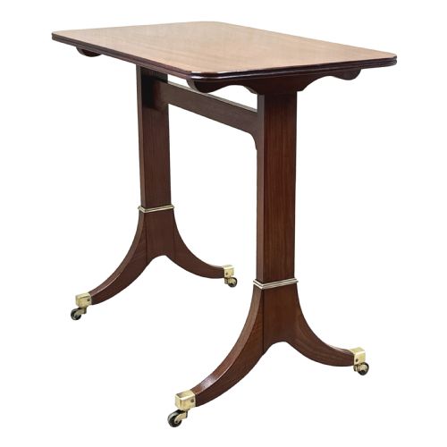 fig 1. A small Georgian dark mahogany library table featuring a rectangular top, a stretchered trestle base, down-swept sabre legs, and brass castors.