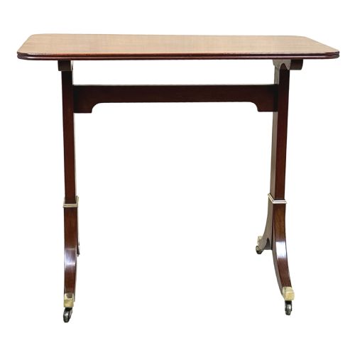 fig 2. A small Georgian dark mahogany library table featuring a rectangular top, a stretchered trestle base, down-swept sabre legs, and brass castors.
