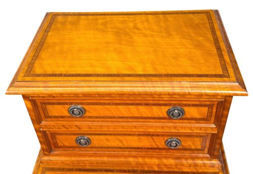 fig 2. A pair of 19th-century golden satinwood bedside chests featuring stepped top sections with drawers, crossbanded inlay, and brass ring handles.