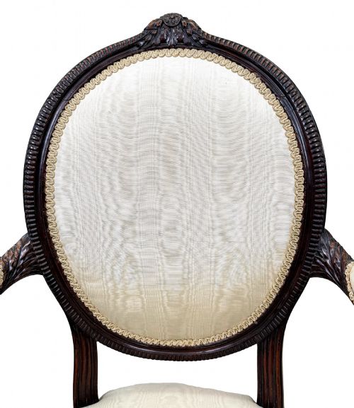 fig 3. An 18th-century Georgian mahogany salon chair featuring an oval back rest, carved wooden frame, and cream silk upholstery.