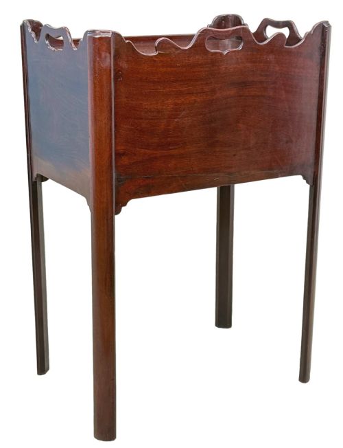 fig 3. An 18th-century Georgian mahogany bedside table with a wavy gallery top featuring pierced hand cutouts, an open shelf compartment, and four square legs.