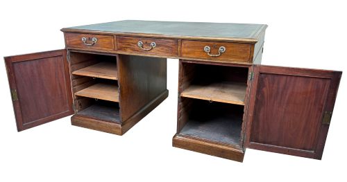 fig 1. An 18th-century Georgian mahogany partners desk featuring three top frieze drawers and twin pedestal cupboards set on a plinth base.