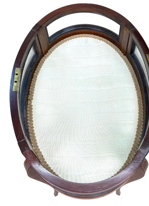 fig 4. An oval late 19th-century mahogany bijouterie display table featuring glass side panels, inlaid floral marquetry, slender cabriole legs, and a cross stretcher.