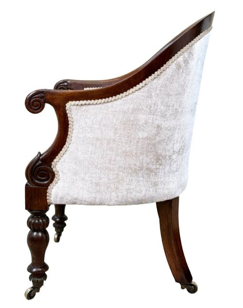 fig 2. A 19th-century Regency period rosewood tub library armchair upholstered in cream fabric with turned legs and brass castors.