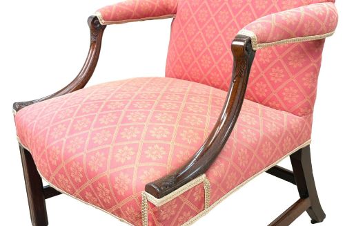fig 1. An 18th-century Georgian mahogany Gainsborough armchair with red patterned upholstery, curved carved arm supports, an H-stretcher frame, and brass castors.
