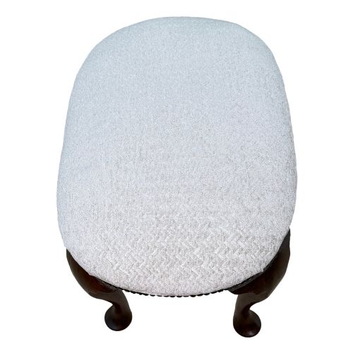 fig 2. An early 18th-century George I walnut stool featuring an oval light grey upholstered seat trimmed with metal studs above four cabriole legs ending in pad feet.