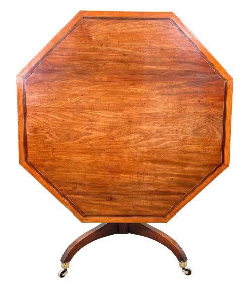 fig 2. An 18th-century Georgian mahogany octagonal centre table with inlaid crossbanding, a central pedestal column, and tripod legs on brass castors.