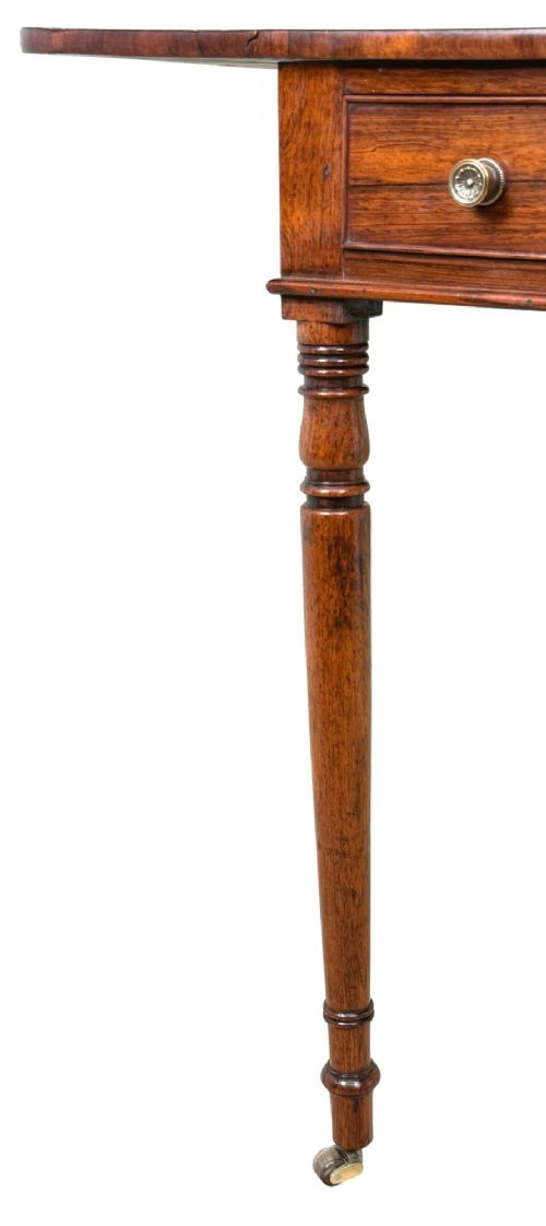 fig 3. An early 19th-century Regency rosewood Pembroke table featuring extended drop leaves, turned legs on brass castors, and a single frieze drawer with brass knobs.