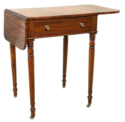 fig 4. An early 19th-century Regency rosewood Pembroke table featuring extended drop leaves, turned legs on brass castors, and a single frieze drawer with brass knobs.