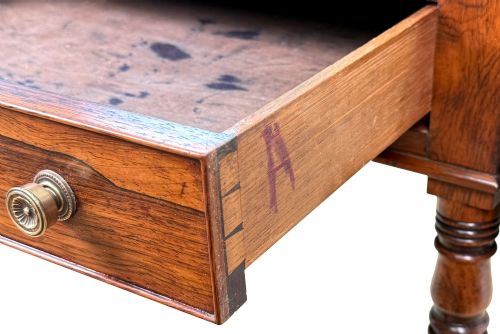 fig 6. An early 19th-century Regency rosewood Pembroke table featuring extended drop leaves, turned legs on brass castors, and a single frieze drawer with brass knobs.