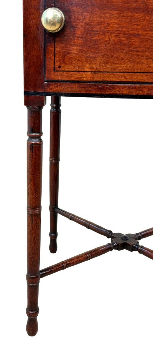 fig 3. An early 19th-century Georgian mahogany side table featuring an oval top, single door cupboard with brass knob, turned legs, and an X-shaped cross stretcher.