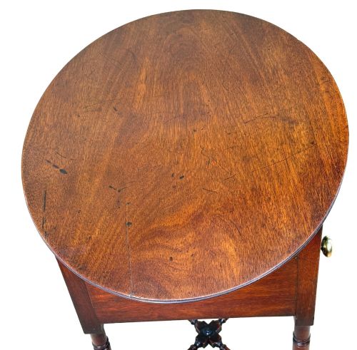 fig 4. An early 19th-century Georgian mahogany side table featuring an oval top, single door cupboard with brass knob, turned legs, and an X-shaped cross stretcher.
