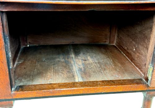 fig 5. An early 19th-century Georgian mahogany side table featuring an oval top, single door cupboard with brass knob, turned legs, and an X-shaped cross stretcher.