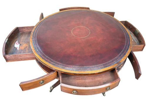 fig 1. A circular Georgian mahogany drum table featuring a brown leather top, frieze drawers with brass ring handles, and a pedestal base with four splayed legs on brass paw castors.