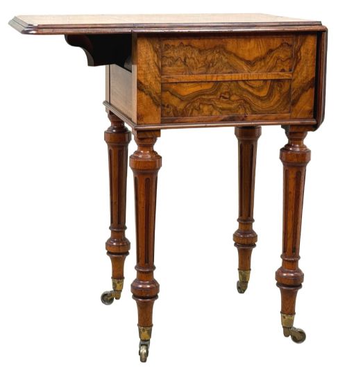fig 6. A 19th-century burr walnut Pembroke side table with a single drawer, two drop-down side leaves, turned fluted legs, and brass castors.