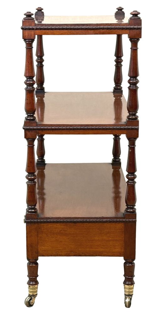 fig 3. An early nineteenth-century Regency mahogany three-tiered etagere whatnot with turned supports, finials, a lower drawer, and brass castors.