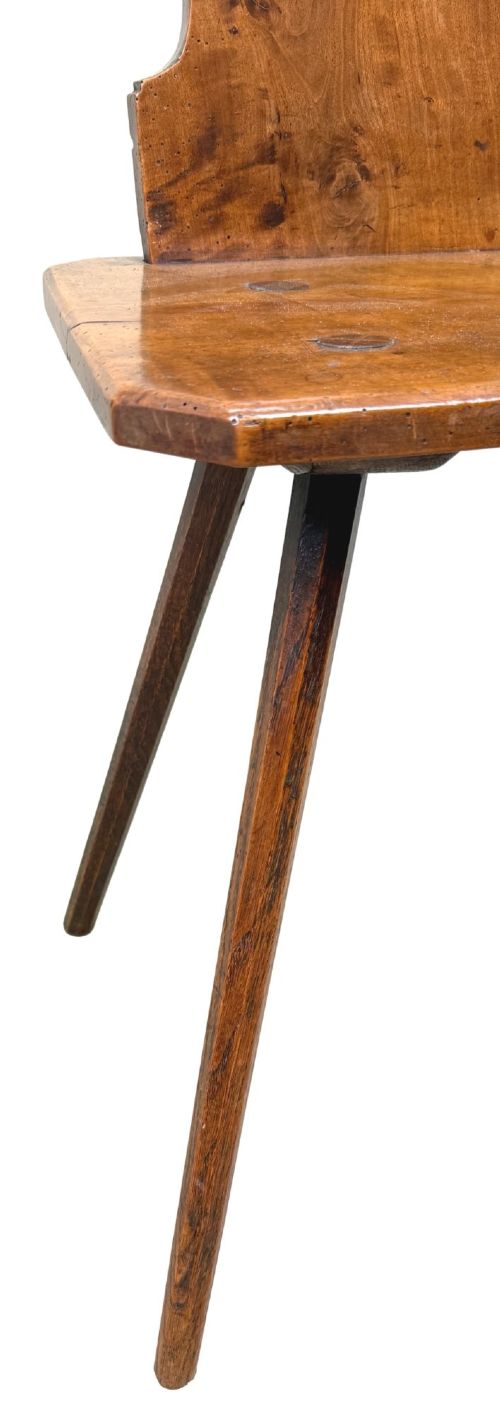A pair of mid-19th-century Swiss escabelle chairs crafted from warm brown fruitwood, featuring circular carved backrests with cut-out motifs and four splayed tapered legs. View IX