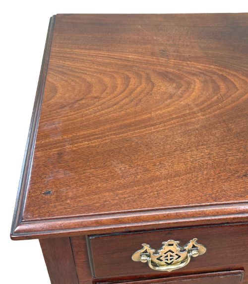 fig 4. An early Georgian mahogany lowboy table featuring three drawers with brass handles, a shaped apron, and four cabriole legs.