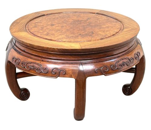 fig 3. A circular 19th-century Chinese export hardwood coffee table featuring an inset burr wood top, carved scroll aprons, and curved legs.