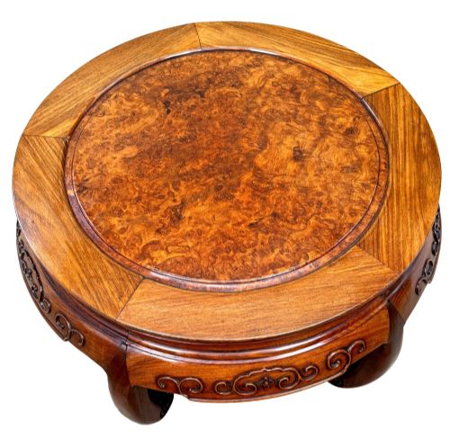 fig 5. A circular 19th-century Chinese export hardwood coffee table featuring an inset burr wood top, carved scroll aprons, and curved legs.