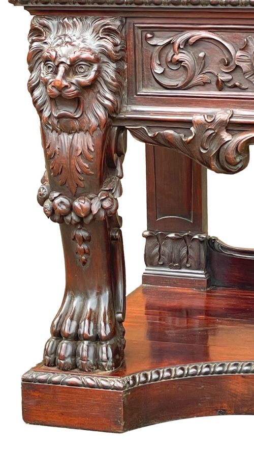 fig 1. A 19th-century dark mahogany display cabinet featuring a carved crest, glazed doors, and lower support with carved lion mask legs.