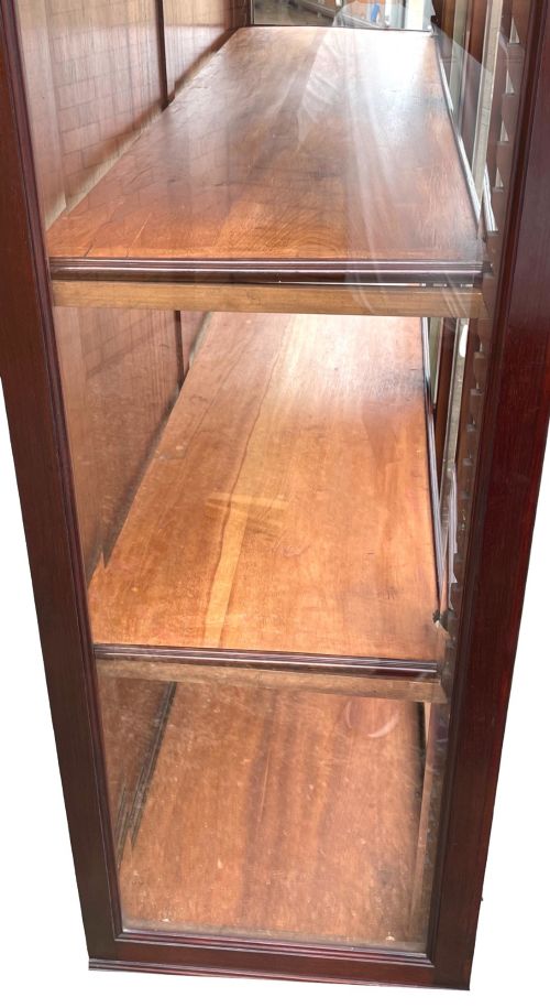 fig 4. A 19th-century dark mahogany display cabinet featuring a carved crest, glazed doors, and lower support with carved lion mask legs.