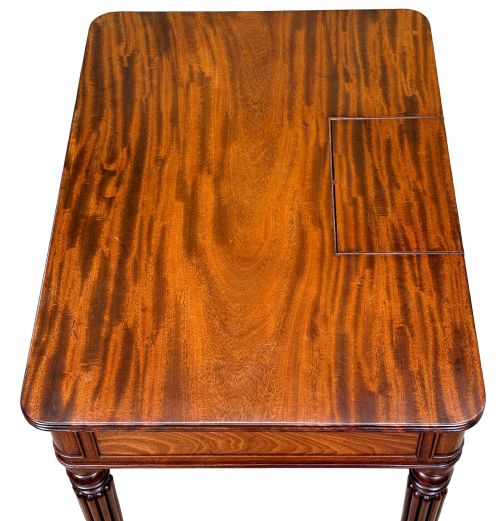 fig 1. A Regency mahogany chamber writing table featuring a single frieze drawer, fluted turned legs on brass castors, and an inset surface hatch.