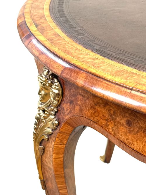 fig 4. A 19th-century burr walnut kidney-shaped writing table featuring an inset leather top, gilt bronze espagnolette mounts, and cabriole legs.