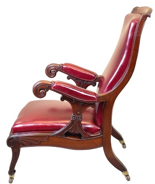 fig 1. A 19th-century high-back mahogany library chair upholstered in deep red leather with carved scroll armrests and brass castors.