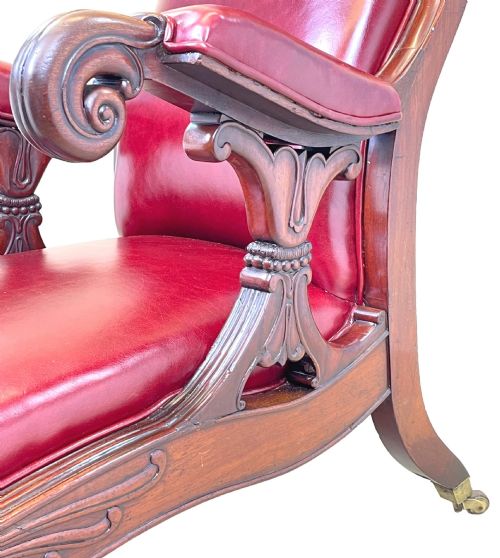 fig 2. A 19th-century high-back mahogany library chair upholstered in deep red leather with carved scroll armrests and brass castors.