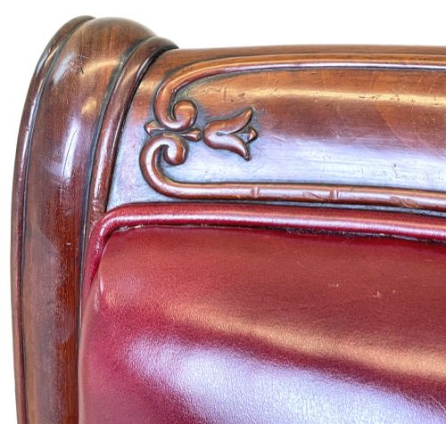 fig 3. A 19th-century high-back mahogany library chair upholstered in deep red leather with carved scroll armrests and brass castors.