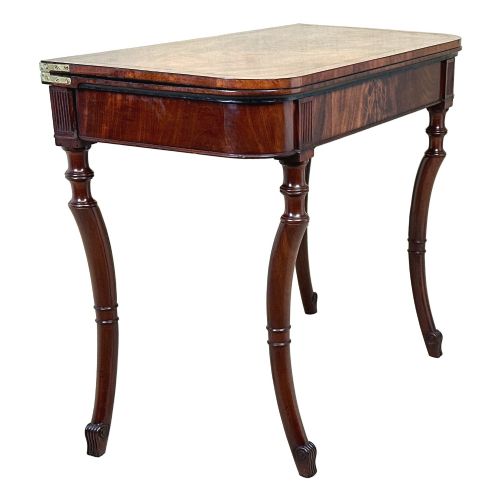 fig 1. A Regency mahogany fold-over tea table featuring a flame mahogany frieze, reeded corner blocks, and four curved legs with ring-turned detailing.