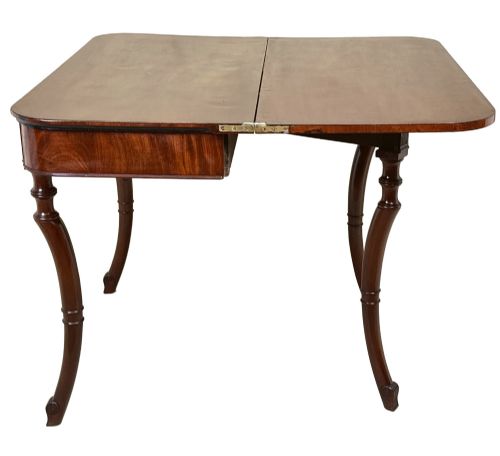 fig 2. A Regency mahogany fold-over tea table featuring a flame mahogany frieze, reeded corner blocks, and four curved legs with ring-turned detailing.