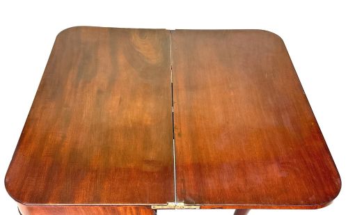 fig 4. A Regency mahogany fold-over tea table featuring a flame mahogany frieze, reeded corner blocks, and four curved legs with ring-turned detailing.