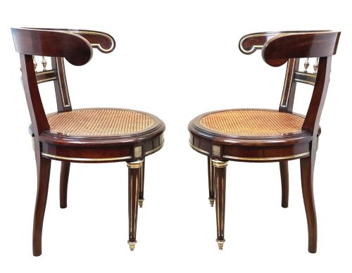 fig 1. A pair of 19th-century French mahogany curved-back salon chairs with brass mounts, spindle details, woven cane seats, and turned front legs.