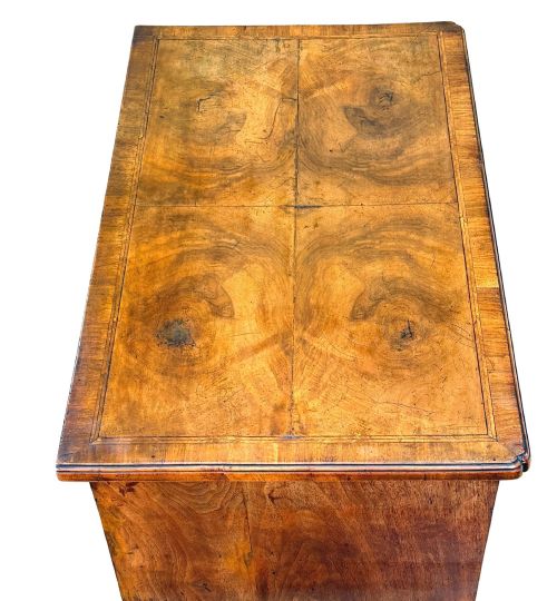 fig 2. An early 18th-century George I walnut lowboy with four drawers, brass drop handles, a shaped apron, and cabriole legs with pad feet.