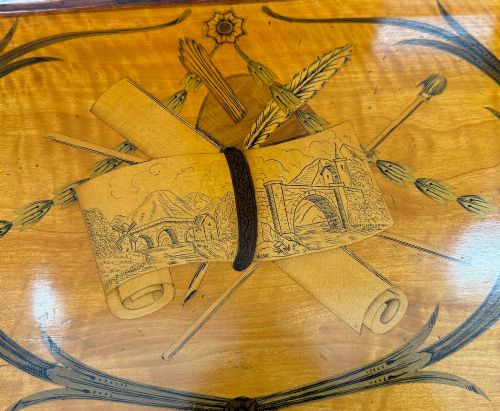 fig 3. A 19th-century inlaid satinwood display cabinet featuring an arched cresting, glazed upper doors, marquetry frieze drawers, and square tapered legs.