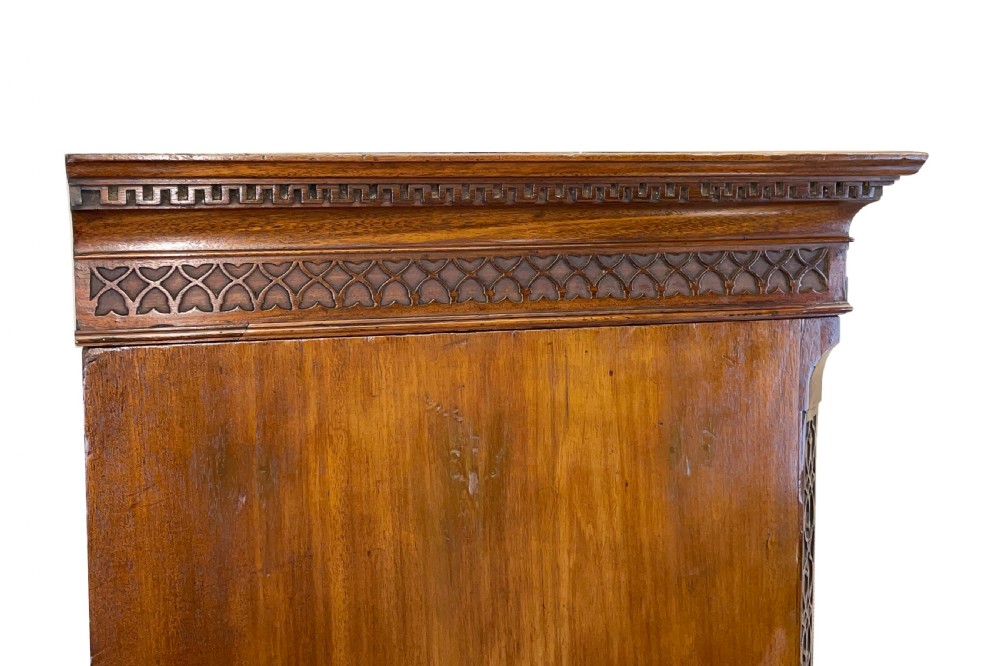 An 18th-century Georgian mahogany chest on chest featuring graduated drawers, carved fretwork, dentil moulding, and brass handles. View VI