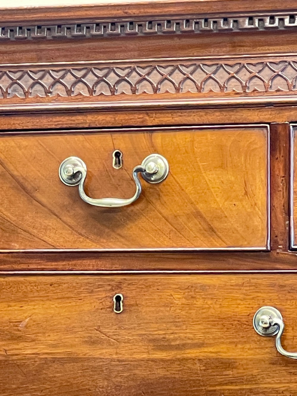 An 18th-century Georgian mahogany chest on chest featuring graduated drawers, carved fretwork, dentil moulding, and brass handles. View VII