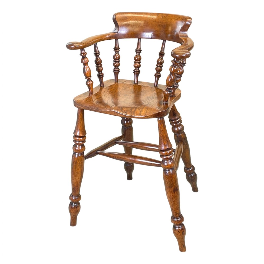 A 19th-century wooden clerk chair featuring a curved horseshoe backrest, turned spindles, a shaped saddle seat, and tall turned legs with double stretchers.
