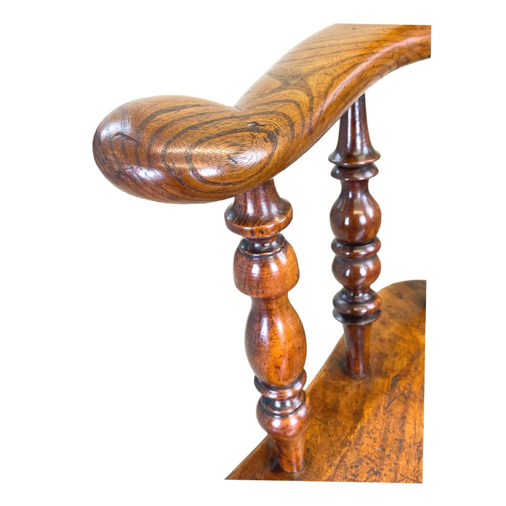 A 19th-century wooden clerk chair featuring a curved horseshoe backrest, turned spindles, a shaped saddle seat, and tall turned legs with double stretchers. View III