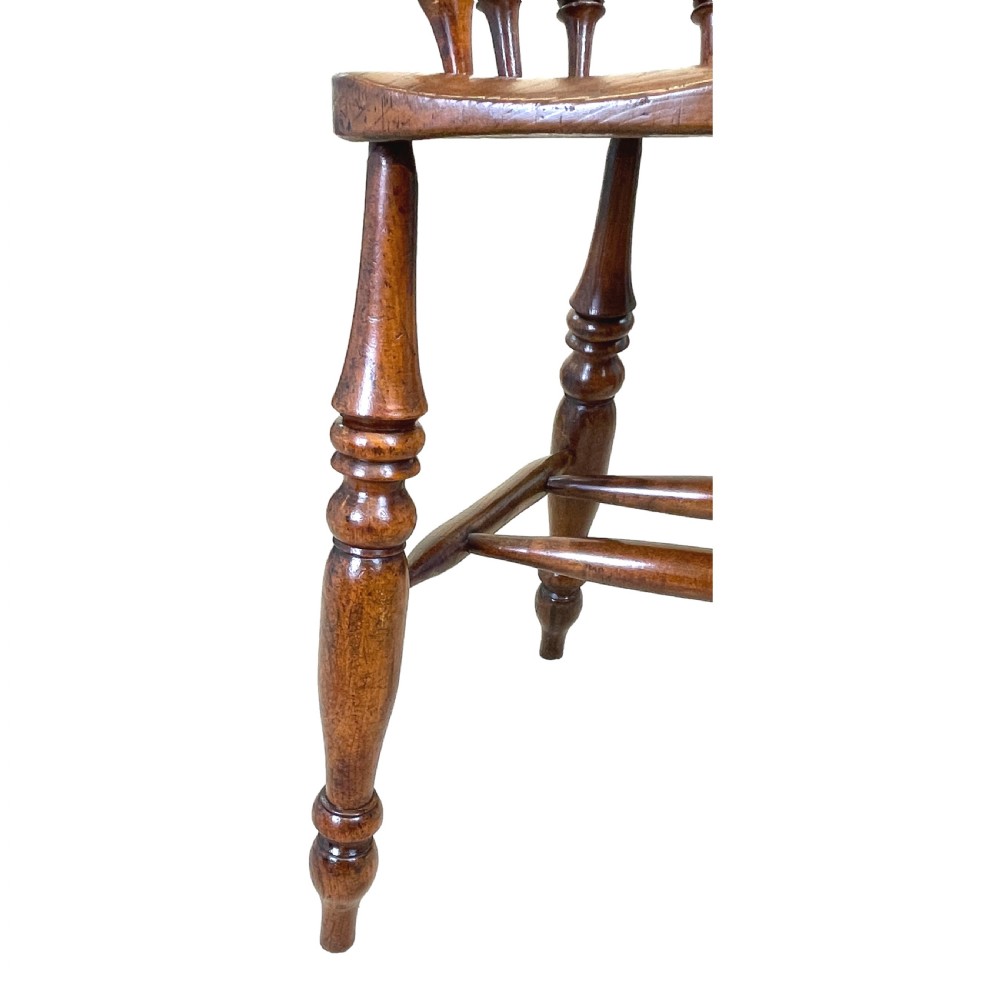 A 19th-century wooden clerk chair featuring a curved horseshoe backrest, turned spindles, a shaped saddle seat, and tall turned legs with double stretchers. View VIII