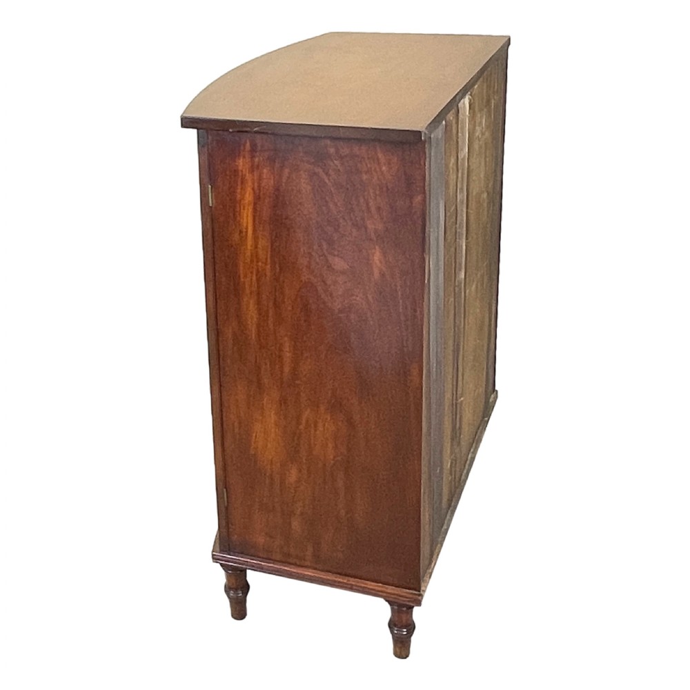 A Regency period bow-fronted mahogany side cabinet featuring two green fabric-panelled doors and turned legs. View VIII