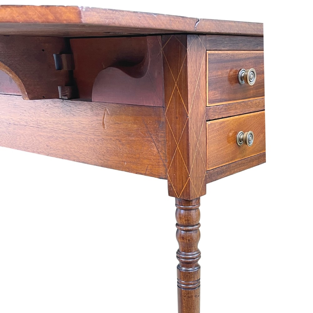 A small Georgian mahogany Pembroke table featuring two drawers with brass handles, fine stringing inlay, two drop leaves, and slender turned legs on brass castors. View VII