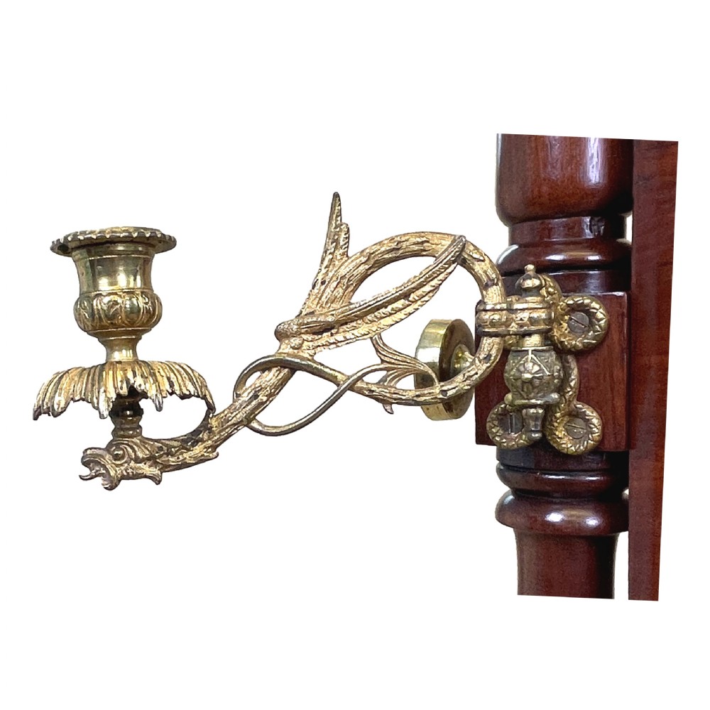 A Georgian mahogany freestanding cheval mirror featuring brass candle sconces, turned upright columns, and splayed legs with brass castors. View II