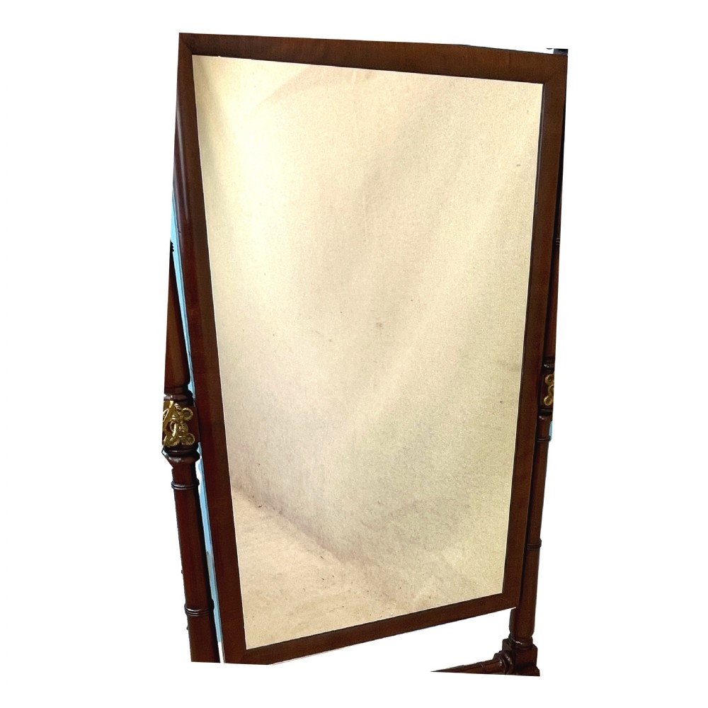 A Georgian mahogany freestanding cheval mirror featuring brass candle sconces, turned upright columns, and splayed legs with brass castors. View III