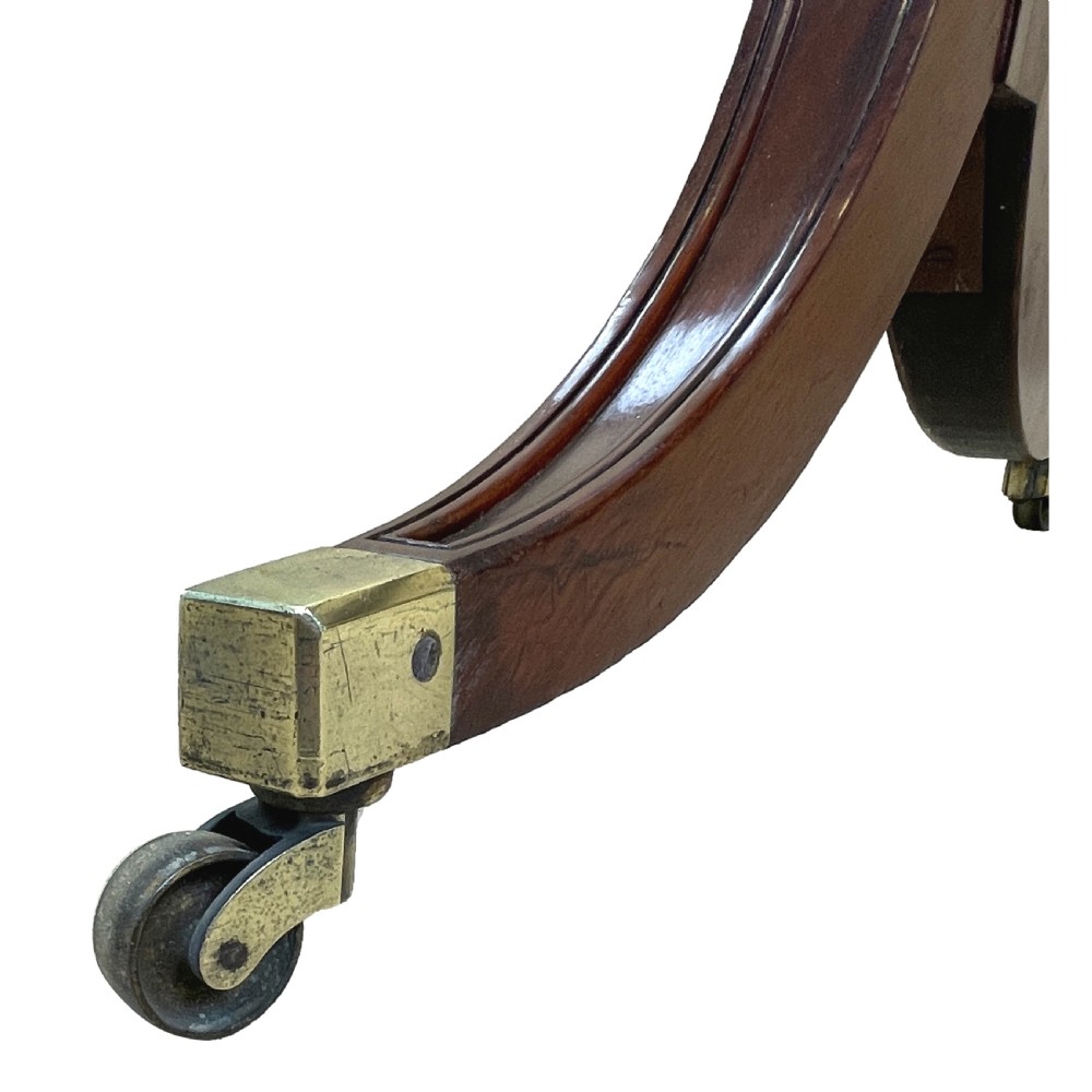 A Georgian mahogany freestanding cheval mirror featuring brass candle sconces, turned upright columns, and splayed legs with brass castors. View IV